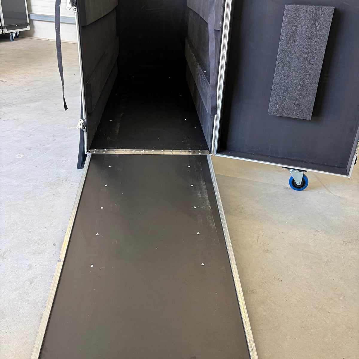Open flight case with the ramp folded out for rolling out the desk